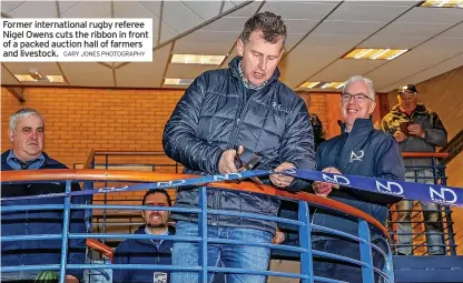  ?? GARY JONES PHOTOGRAPH­Y ?? Former internatio­nal rugby referee Nigel Owens cuts the ribbon in front of a packed auction hall of farmers and livestock.