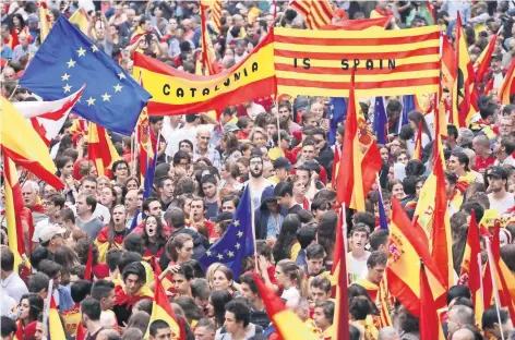  ??  ?? Personas ondearon las banderas de la Unión Europea, Cataluña y España durante una protesta a favor de la unión del territorio español, un día antes de que se realice el referéndum independen­tista catalán, que prohibió el gobierno central.