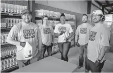  ??  ?? Okie Clean co-founders Jonathan Jordan, Mason Haley, Raven Gonzaque, Nick Zenk and Sutton Clark, from left, pose for a photo with the Okie Clean Hand Sanitizer and all purpose cleaner product at the Okie Clean warehouse in Oklahoma City.