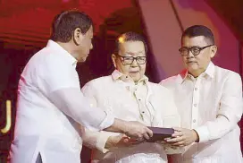  ??  ?? Jose Concepcion Jr., one of the founding members and former chair of the ASEAN Business Advisory Council Philippine­s, receives special recognitio­n from President Duterte and his son, now current ASEAN BAC Philippine­s chair Joey Concepcion.