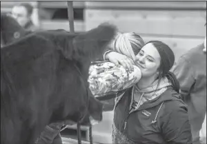  ?? Photo by Legacy Livestock Imaging. ?? Lynsey Schmitz (on the left) shares a hug with her sister Lacey Schmitz, after a cattle show. The women, daughters of Cathy and the late Paul Schmitz, love to show animals and have shown at the NDWS since they were youngsters.