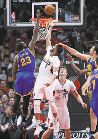  ?? Scott Strazzante / The Chronicle ?? The Warriors’ Draymond Green and Zaza Pachulia stop Portland’s Evan Turner during the first quarter. Golden State took leads of 14-0 and 41-13 in putting away Game 4 early.