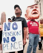  ?? Bill Pugliano / Getty Images ?? Protesters, including a man wearing a mask of Michigan Gov. Rick Snyder, demonstrat­e outside Detroit’s historic bankruptcy trial Sept. 2.