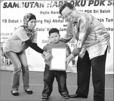  ??  ?? Abang Johari receives a memento from a Sri Satok PDK trainee at the event.