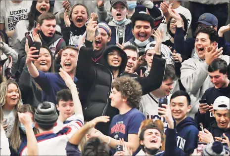  ?? Jessica Hill / Associated Press ?? Former UConn player James Bouknight, center, hides in the student section after being ejected from his courtside seats by an official in the second half Saturday in Storrs.