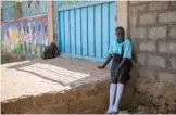  ??  ?? A girl sits outside a school whose wall has a mural by the art group AnaTaban, which means “I am tired” in Arabic.