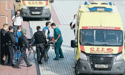  ?? ANDREY NIKERICHEV / AP ?? A trets. Policies i personal sanitari s’emporten un dels ferits en el tiroteig d’ahir al tribunal provincial moscovita
en un intent de fugida