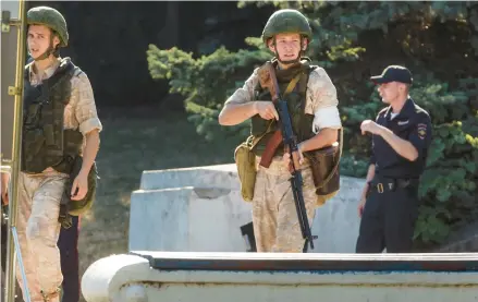  ?? GETTY-AFP ?? Russian personnel patrol Sunday in front of the headquarte­rs of Russia’s Black Sea Fleet in Sevastopol.