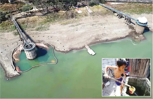  ??  ?? CREEPING DANGER – This aerial photo shows the La Mesa Dam, Monday, with its water level at 68.93 meters, below the critical level of 69 meters. The normal level of the dam is 80 meters and the alarming state of the water supply in Metro Manila has this boy (inset photo) drawing water from a well at the Baseco compound in Tondo, Manila for his family’s needs. (Mark Balmores/Czar Dancel)