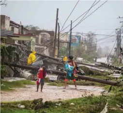  ?? AP PHOTO ?? AFTERMATH: Residents of Caibarien, Cuba, navigate through downed power lines after Irma blew through.