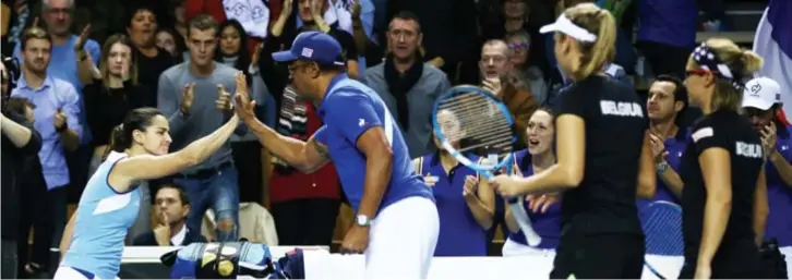  ?? FOTO REUTERS ?? Zo verschille­nd zijn de emoties bij winst en verlies: de Fransen vieren uitbundig, Elise Mertens en Kirsten Flipkens druipen in stilte af naar de kant.