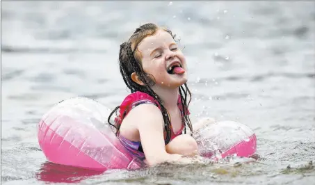  ?? Justin Tang ?? The Associated Press Nora Ward, 6, plays at Mooney’s Bay Beach as a heat wave continues Thursday in Ottawa. Heat warnings are in effect across southern Quebec, Ontario and the Atlantic region of the country, but temperatur­es are expected to drop...