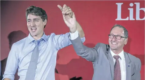  ?? THE CANADIAN PRESS FILES ?? Richard Hebert, the Liberal candidate for the byelection in the Lac-Saint-Jean riding, right, cheers with Prime Minister Justin Trudeau during a Liberal party rally in Dolbeau-Mistassini, Que, on Thursday, Oct. 19.