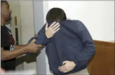  ?? NIR KEIDAR — THE ASSOCIATED PRESS ?? A 19-year-old dual U.S.-Israeli citizen covers his face as he is brought to court in Rishon Lezion, Israel, Thursday. Israeli police said they have arrested a Jewish Israeli man who is the prime suspect behind a wave of bomb threats against Jewish...