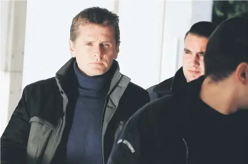  ?? — Reuters photo ?? Vinnik, a 38 year old Russian man suspected of running a money laundering operation using bitcoin, is escorted by police officers to a court in Athens, Greece Dec 13.