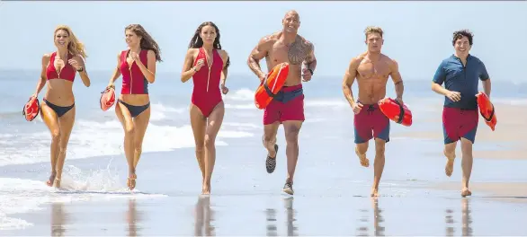  ?? PARAMOUNT PICTURES ?? Kelly Rohrbach, left, Alexandra Daddario, Ilfenesh Hadera, Dwayne Johnson, Zac Efron and Jon Bass sport the famous Baywatch beach attire in the new film.