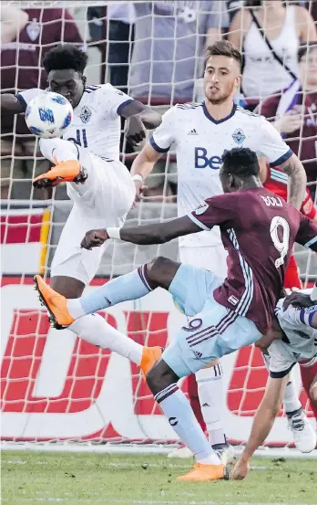  ?? JACK DEMPSEY/THE ASSOCIATED PRESS ?? Vancouver Whitecaps forward Alphonso Davies kicks the ball away from Colorado Rapids forward Yannick Boli Friday as the Whitecaps earned a 2-1 victory in Commerce City, Colo.