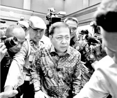  ??  ?? In this file photo policeman guard Novanto (centre) as he attends court for his verdict in Jakarta. — Reuters photo