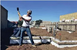  ?? NEW MEXICAN FILE PHOTOS ?? A staffer with YouthWorks swings a pick at a Santa Fe Habitat for Humanity homesite in Oshara Village.