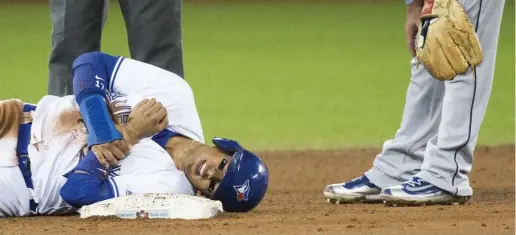  ?? CARLOS OSORIO/TORONTO STAR ?? Tampa Bay’s Daniel Robertson, right, stepped on the arm of Ryan Goins in the sixth inning Wednesday. The Jays shortstop left the game with an ugly gash above his left wrist. Toronto, with a strong performanc­e from starter Marcus Stroman, edged the Rays 3-2.