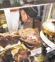  ??  ?? Kimberly Thorn gathers chocolates one-by one as customers call out their favorite choices such as “Supreme’s Raspberry Dark,” and “Cabernet Sauvignon Truffle.”