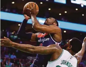  ?? AFP PIC ?? Wizards’ John Wall tries to score as Celtics’ Amir Johnson defends in their game on Friday.
