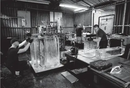  ?? Photos by Yi-Chin Lee / Staff photograph­er ?? DLG Ice Factory carvers Don Lowing, from left, Christophe­r Barnes and Burr Rasmussen prepare an order for the Frostival.