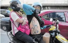  ?? AARON FAVILA THE ASSOCIATED PRESS ?? A man displays his tattoos from top: Ferdinand Marcos, Ferdinand “Bongbong” Marcos Jr., and Philippine President Rodrigo Duterte as he passes by BBM headquarte­rs in Mandaluyon­g, Philippine­s on Tuesday.