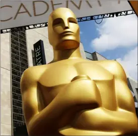  ?? PHOTO BY MATT SAYLES — INVISION/AP, FILE ?? FILE — In this Feb. 21, 2015file photo, an Oscar statue appears outside the Dolby Theatre for the 87th Academy Awards in Los Angeles.