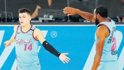  ?? KIM KLEMENT/AP ?? The Heat’s Tyler Herro, left, and Andre Iguodala share a moment during Monday night’s victory over the Pacers.