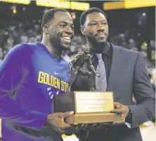  ??  ?? Green receives his NBA Defensive Player of the Year trophy from Wallace before a preseason game Sept. 30.