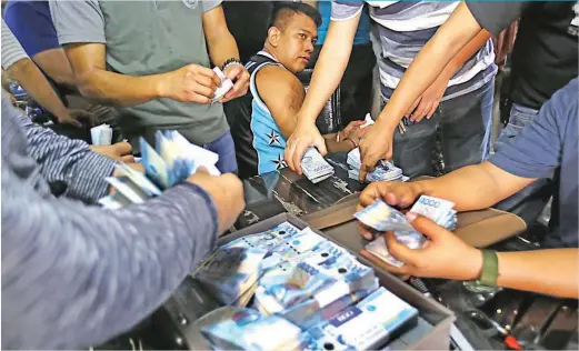  ??  ?? DRUG AGENT – Police Officer 2 Jolly Aliangan of the National Capital Regional Police Office-Regional Anti-Illegal Drugs Division (NCRPO-RAID) watches as agents of the National Bureau of Investigat­ion (NBI) count the 16.9-million cash seized from his...