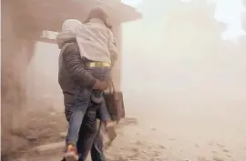  ?? SYRIAN CIVIL DEFENSE WHITE HELMETS/ASSOCIATED PRESS ?? A member of the Syrian Civil Defense group carries a girl who was wounded during shelling by Syrian government forces, in Ghouta, near Damascus, Syria.