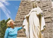  ?? AMY DAVIS/BALTIMORE SUN ?? Mary Claire Miller, of Baltimore, a former parishione­r at Blessed Sacrament Church, examines the cleaned statue.