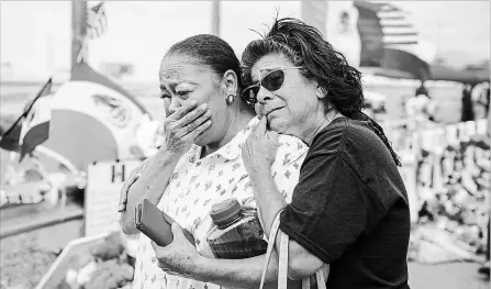  ?? CALLA KESSLER NEW YORK TIMES ?? Laura Caballero, right, embraces a fellow community member at a makeshift memorial at the Walmart in El Paso, Texas. The city opened a grief centre on Tuesday to help people cope, offering counsellin­g, travel assistance and financial support.