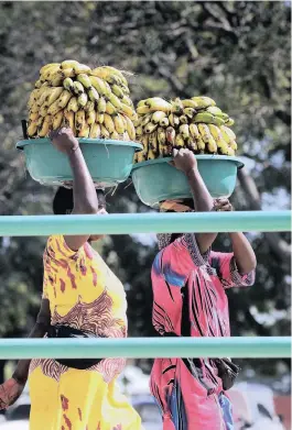  ?? PICTURE: PABALLO THEKISO ?? BALANCING ACT: Carrying bananas on their heads, women walk through the streets of Dar es Salaam.