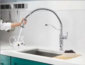  ??  ?? The Tournant faucet by Kohler with its three-function, pull-down spray head lets you put the water exactly where you need it, while a special BerrySoft setting is gentle enough for washing fruits and vegetables.