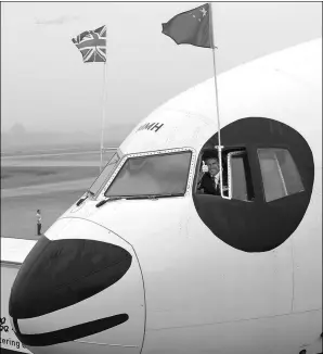  ?? XIE MINGGANG / FOR CHINA DAILY ?? A British Airways captain poses for photograph­s on a panda-themed airplane at the Chengdu Shuangliu Internatio­nal Airport in Sichuan province.