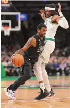  ?? Maddie Meyer/Getty Images ?? Nets guard Kyrie Irving drives towards the basket past the Celtics’ Robert Williams III during the first half on Wednesday in Boston.