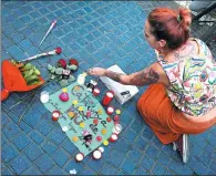  ?? SERGIO PEREZ / REUTERS ?? A woman places a candle on a placard that says, in Spanish and Catalan, “Catalonia, place of peace”, near where a van struck pedestrian­s in Barcelona.