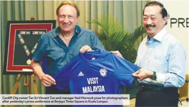  ??  ?? Cardiff City owner Tan Sri Vincent Tan and manager Neil Warnock pose for photograph­ers after yesterday’s press conference at Berjaya Times Square in Kuala Lumpur.