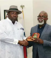  ??  ?? Bayelsa State Governor, Seriake Dickson (left) presenting a souvenir to NFF President, Amaju Pinnick, during the courtesy visit of the NFF Board to Dickson at the Government House in Yenagoa…on Tuesday