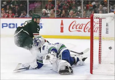  ?? The Associated Press ?? Minnesota Wild forward Charlie Coyle scores on Vancouver Canucks goaltender Richard Bachman during first-period NHL action in St. Paul, Minn., on Thursday night. The Canucks lost 6-2.