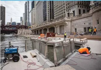  ?? SANTIAGO COVARRUBIA­S / SUN- TIMES ?? Crews put the finishing touches on the Chicago Riverwalk on Wednesday.