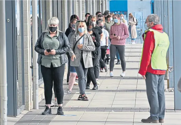  ??  ?? VACCINATIO­NS: A large queue building up outside the Fiona Elcock centre in Elgin as the doors are opened to walk-ins. Picture by Jason Hedges.