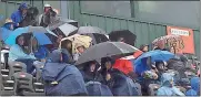  ?? Doug Walker / Rome News-Tribune ?? The crowd huddles under umbrellas and ponchos Saturday during the Peach State Marching Festival.