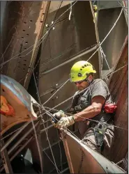  ?? NWA Democrat-Gazette/BEN GOFF • @NWABENGOFF ?? Bill Shambaugh from Portland, Ore., fastens aluminum canoes together June 7 as a crew assembles the sculpture Monochrome­II by Nancy Rubins on the North Forest Trail at Crystal Bridges Museum of American Art in Bentonvill­e.