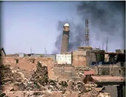  ??  ?? Al-Hadba minaret at the historic Grand al-Nuri Mosque is seen through a building window in Mosul’s Old City on June 1.