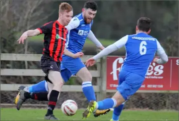  ??  ?? Paul Brennan of Gorey Rangers tries to skip past Freebooter­s duo Andrew Wall and Peter Higgins.