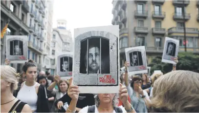  ?? Picture: EPA-EFE ?? PUSHBACK. Protesters with photo of Catalan former vice-president Oriol Junqueras, centre, as hundreds block a street after the sentences given to pro-independen­ce leaders in Barcelona yesterday.